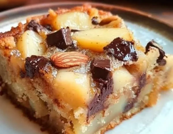 Gâteau moelleux poire, amandes et chocolat sur une assiette gourmande