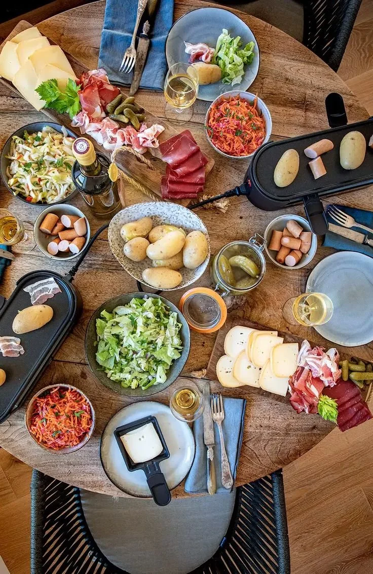 Image d'une raclette fondue servie avec des légumes et des pommes de terre