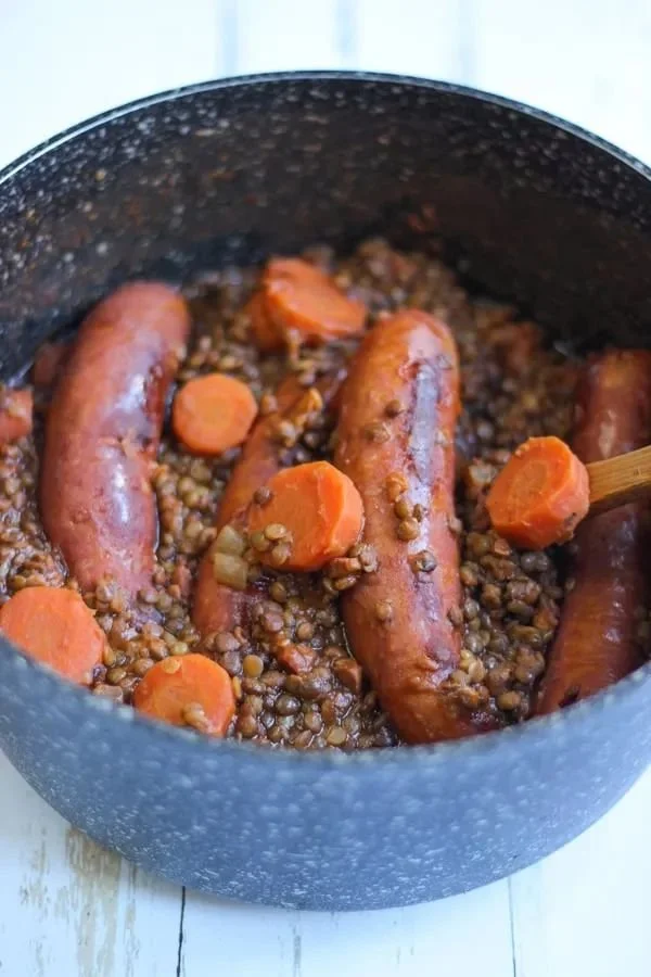Plat de saucisses aux lentilles prêt à servir, recette délicieuse et réconfortante.
