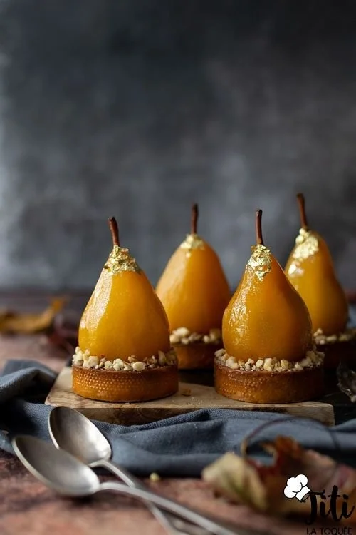 Tartelettes poire chocolat praliné garnies de crème et de praliné croquant.