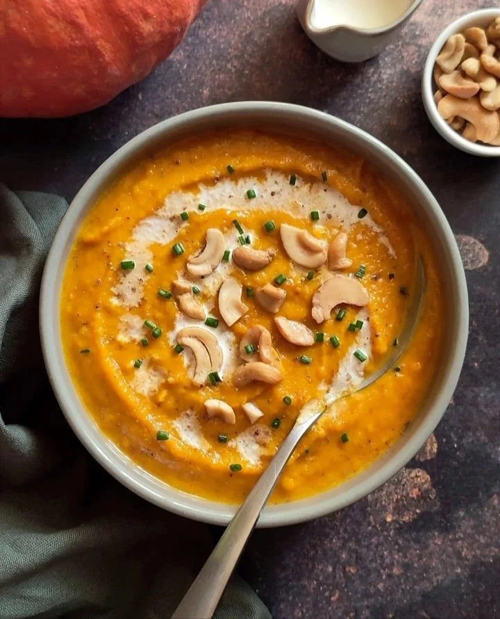 Bol de velouté potimarron d'automne décoré avec des herbes fraîches